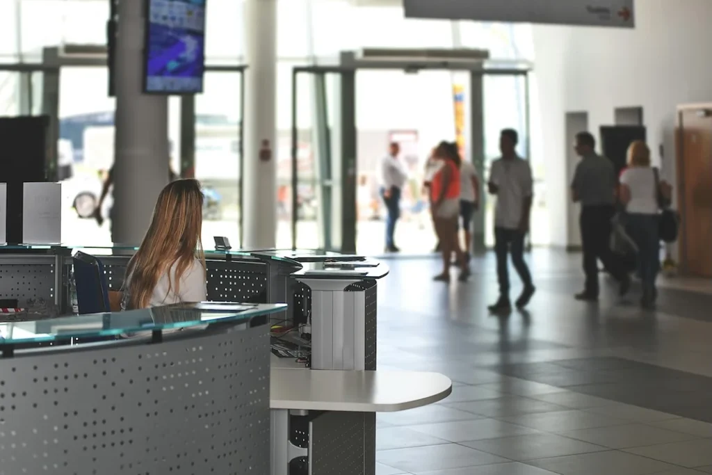 clinic reception desk with visitors and digital signage screen