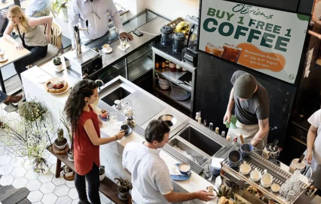 Digital signage screen in coffee shop promoting buy one get one free coffee offer