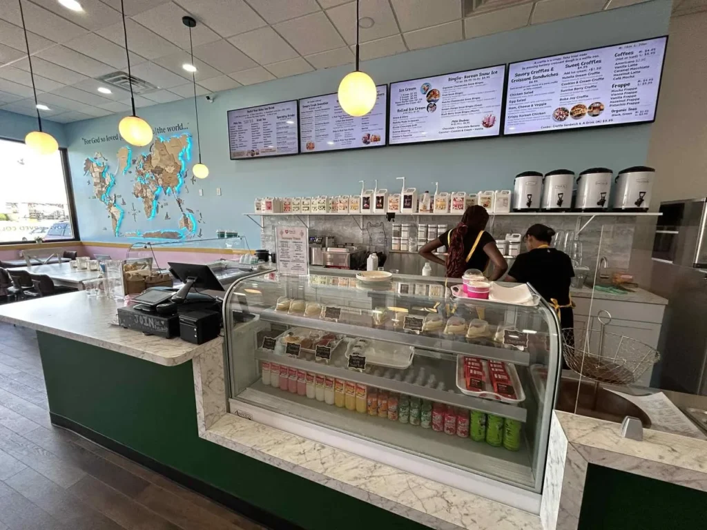 Cafe interior with digital menu boards displaying food and drinks